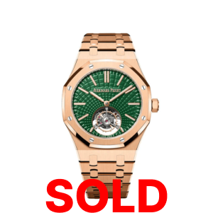 A gold watch with green face and roman numerals.